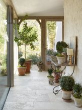 A glassed-in walkway leads to the children’s rooms. “When designing your own home, there is a freedom in experimenting, ” says Brooke. “It’s like a laboratory of design ideas.” The pots are from Giannetti Home.