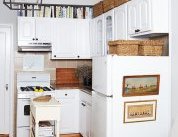 Alex found clever ways to display Cole’s growing art collection—including the side of the refrigerator. “It disguises the appliance that sits right next to the sofa, ” says Alex. “Now it feels softer and more a part of the living arrangement.” He used adhesive hooks to hang the landscape prints.