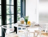 The breakfast table sits on one end of the kitchen, where French doors open out to an English garden.