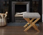 We love how the glimmering brass base on this glam ottoman wonderfully complements the beautiful carvings on the stone fireplace.